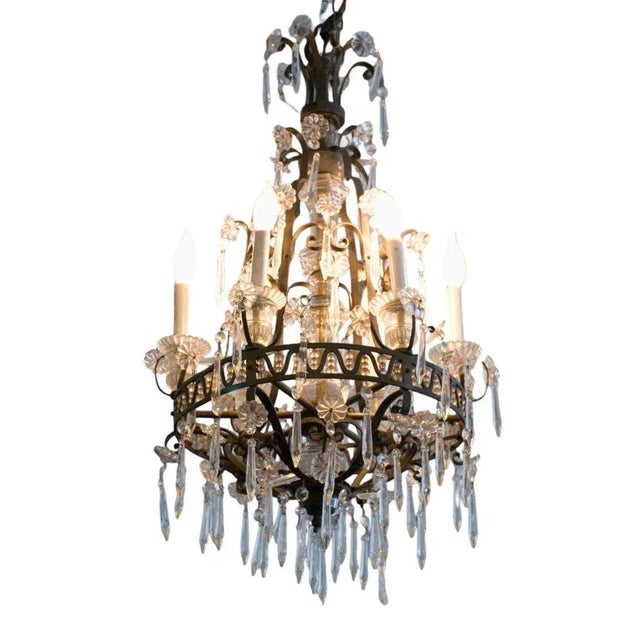 A breathtaking French crystal and bronze chandelier, adorned with delicate crystal flowers and cascading tiers of...