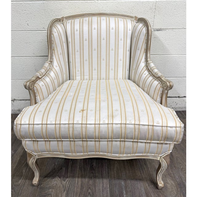 This is an elegant vintage Sam Moore bergère lounge chair featuring a carved Louis XV style hardwood frame with champagne...