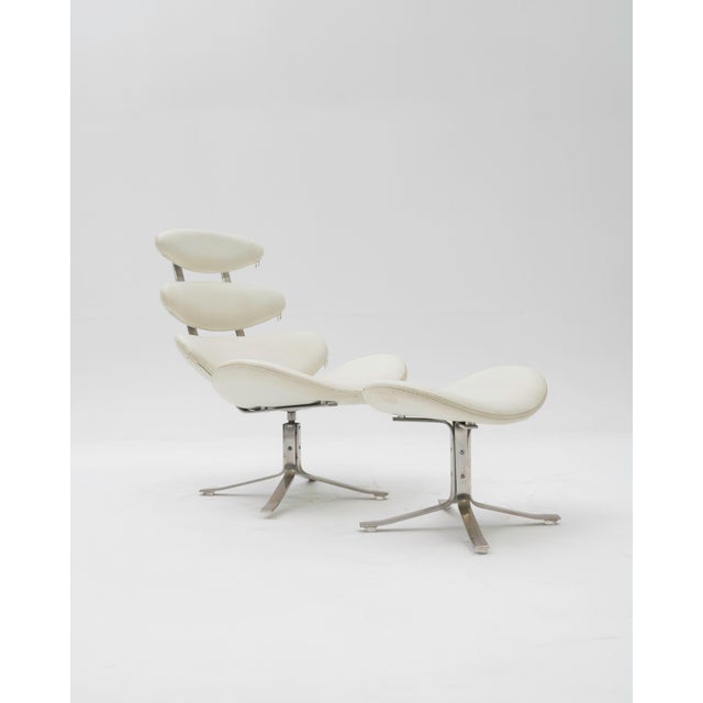The "Corona" armchair with matching footstool, originally designed by Poul M. Volther and produced by Erik Jørgensen, is a...