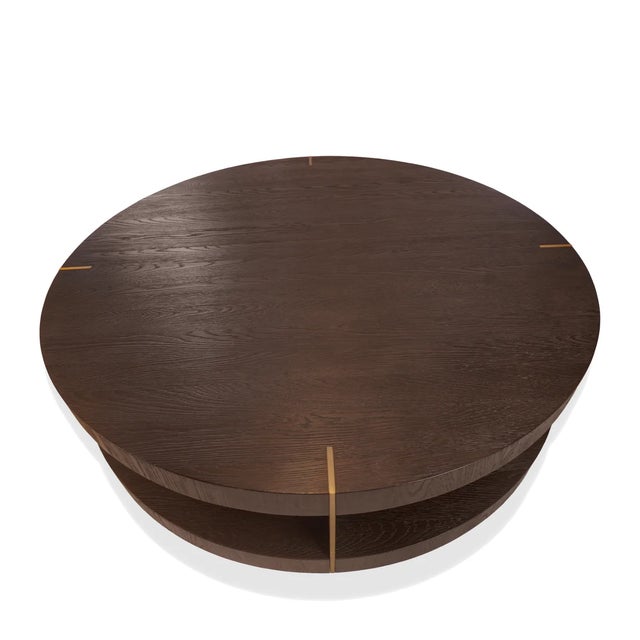 The Verrazano Round Coffee Table by RH features a bold, architectural presence, defined by its sculptural circular form...