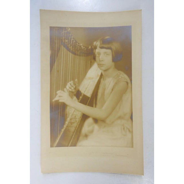 Circa 1920's gelatin silver studio photograph of young girl playing harp. Stamped Underwood & Underwood New York. Very...