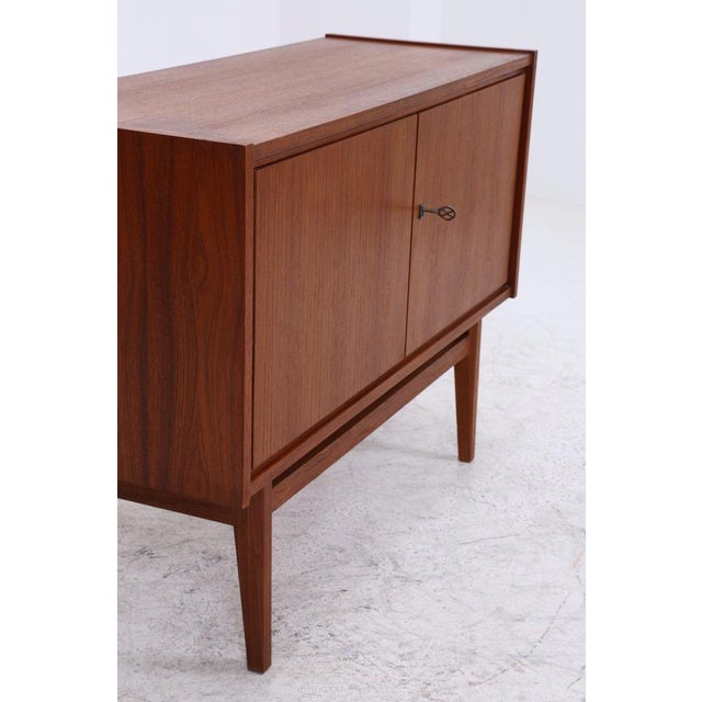 Vintage teak chest of drawers from the 1960s with a clean, straight design and beautiful wood grain. The raised shape with...
