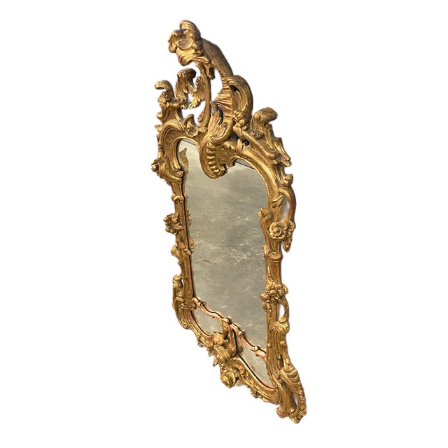 Vintage Italian giltwood Rococo style wall mirror with ornate hand-carved stylized leaf, vine, acanthus leaf, and floral...