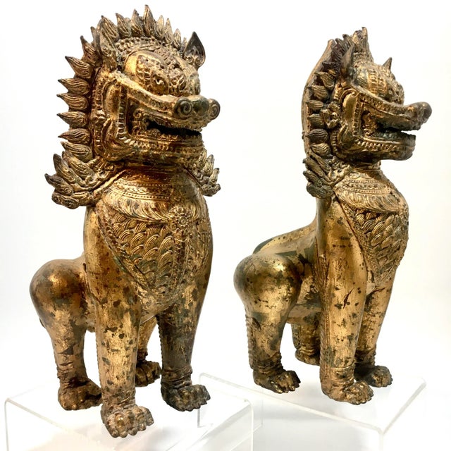 This unique pair of gilded bronze Foo Dogs are nicely executed and detailed with an aged gold finish with some verdigris...