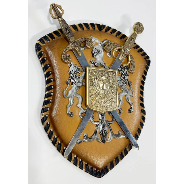 Vintage souvenir style coat of arms with medieval crest, dual swords, two lions and shield. Wall mounted and set on...