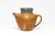 Sculptural pitcher glazed in warm brown hues with muted rim. The handle shows fine incised detail where it joins the body,...