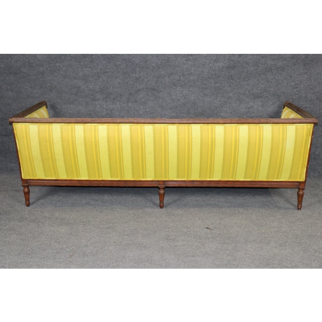 This handsome French Louis XVI style “even arm” walnut sofa carries the quiet authority of neoclassical design — balanced,...