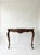 A striking antique French console table in the Louis XV style, this piece features a beautifully carved solid walnut base...