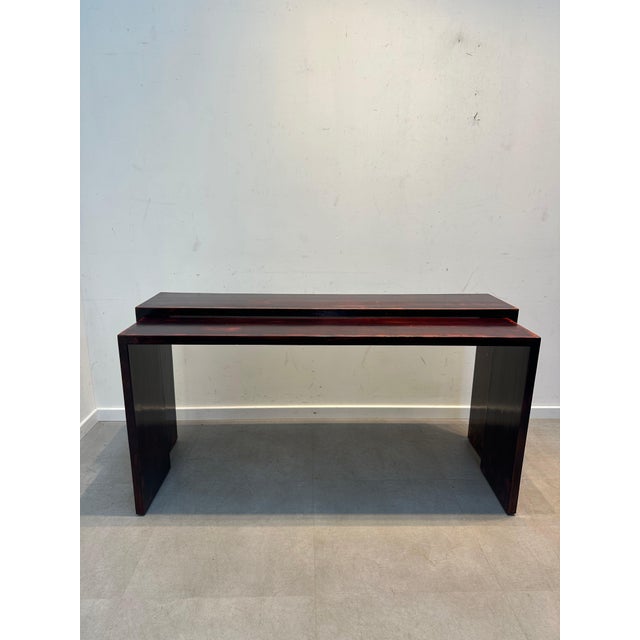 Elegant set of 2 nesting console tables in a minimalist design. Crafted with clean architectural lines and finished in a...