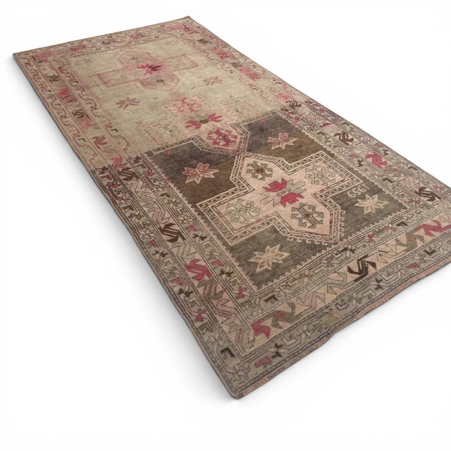 This antique Karabagh runner, approximately 110 years old, presents a striking yet nuanced composition centered around...