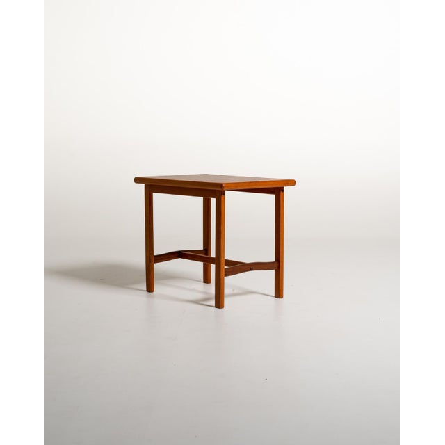 Rectangular teak tabletop with rounded edges, a slender frame, and contoured lower crosspieces. Made by alberts, sweden,...