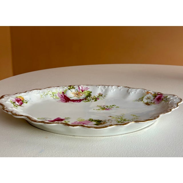 This antique porcelain serving plate is marked on the reverse Limoges AL France with an anchor. This mark was used by...
