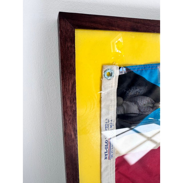 A striking vintage nautical signal flag featuring a bold combination of maritime colors and geometric design, presented in...