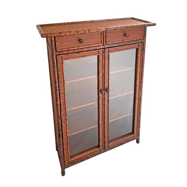 Bring warm British Colonial character and natural texture to your home with this lovely vintage glass door cabinet...