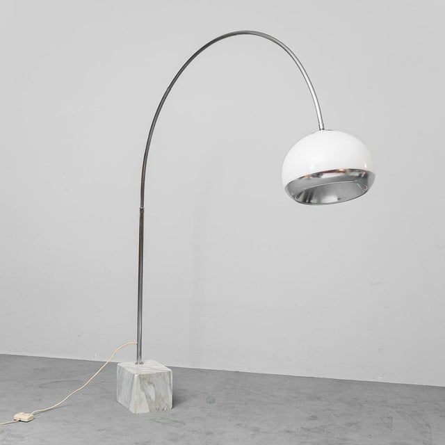 Arc floor lamp. By Guzzini. Marble base, chromed metal arch, and plastic lampshade. Excellent condition with some signs of...