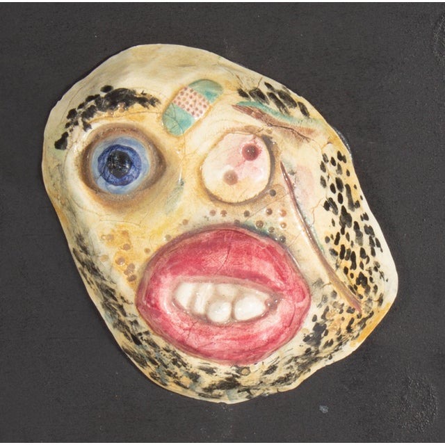 A 1970s ceramic tile by the American artist Mark Bulwinkle (born 1946). This ceramic piece depicts an abstract face with...