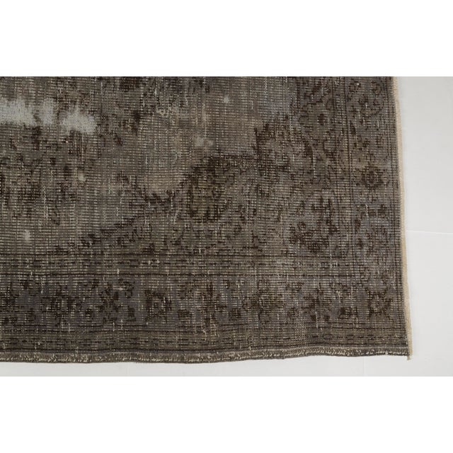 This is a vintage Turkish Oushak rug from the Mid 20th Century. The piece was hand-knotted.