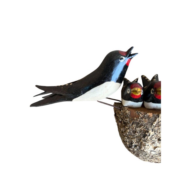 Austrian folk art. Wood carved swallows with babies in nest.