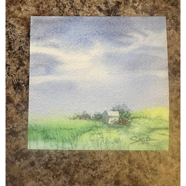 A peaceful field of green and wildflowers leads to a cozy cottage beneath a dramatic pastel sky. A charming rural scene...