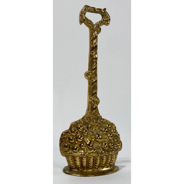 Heavy vintage cast brass door stop featuring base depicting a woven basket of flowers. The solid brass handle has a...
