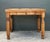 This charming vintage table is a quintessential example of rustic farmhouse design, crafted from warm, honey-hued knotty...
