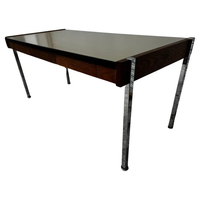 This desk was made in the Harvey Probber style. It's made of walnut and has a laminate top. The legs are chrome and it has...