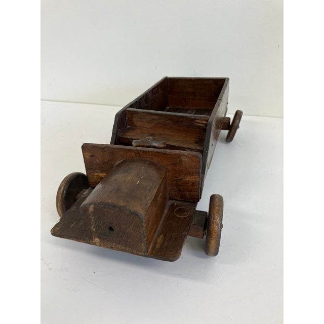 Age: Circa 1920s–1930s Material: Hand-carved solid wood with original patina and wooden wheels Early American folk art;...