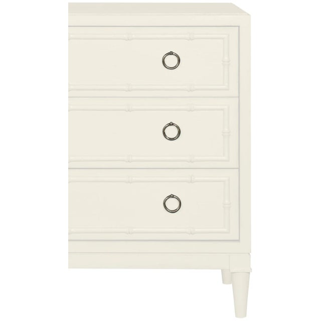 This beautifully detailed piece features carved bamboo details, turned legs, brushed nickel ring pulls and three drawers....