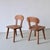 Pair of rustic cabin chairs with engraved slat backs and sculpted wooden seats. Made from warm-toned pine with angular...
