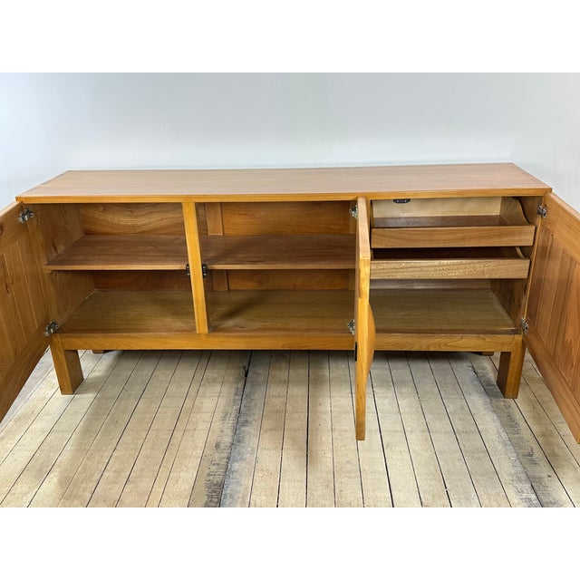 Solid elm sideboard by Maison Regain, 1970. The front features three doors with horizontal and vertical wood joinery. The...