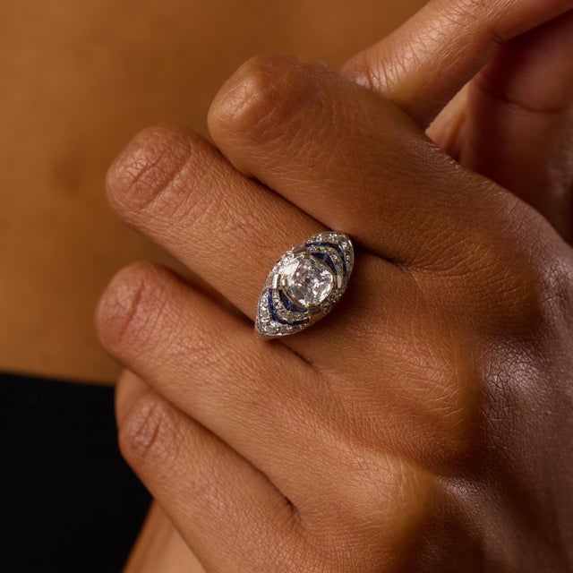 This exceptional Art Deco engagement ring centers on a stunning 1.20 carat old mine cut diamond, certified by GIA...