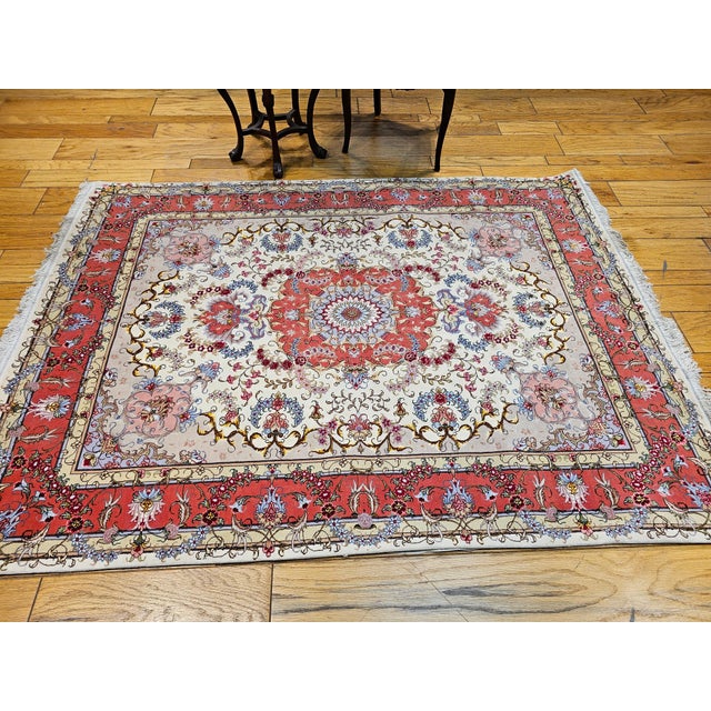 5’ 1” x 6’ 10” A very fine hand-woven Persian Tabriz area rug in floral design with silk highlights from the late 1900s....