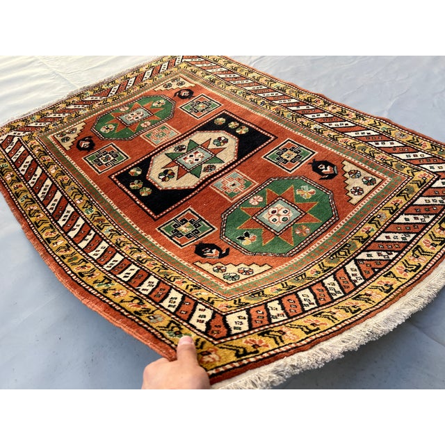 A bold hand-knotted Caucasian Kazak rug in the Sevan Star triple medallion format — two green-framed octagonal star...
