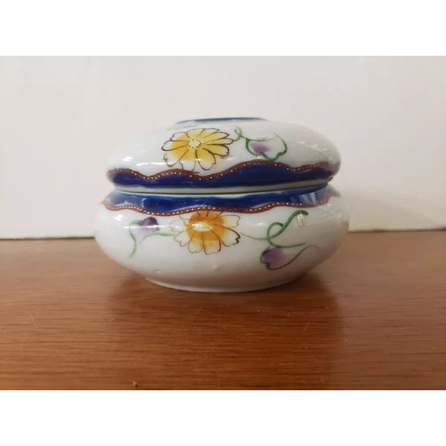 This is a Circa 1950 Japanese Porcelain Floral Motif Hair Receiver. It measures 2 7/8" high with the lid and 5“ in...