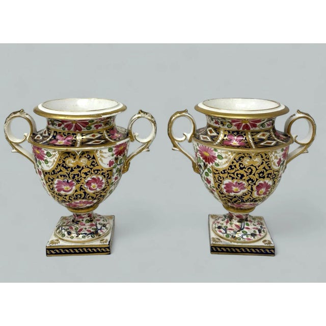 An Exceptionally fine and quite rare pair of hand painted Royal Crown Derby Twin Handle Urns Vases of Campana outline,...