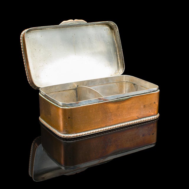 This is a small antique tobacco tin. An English, copper and silver plate lidded box, dating to the Edwardian period, circa...