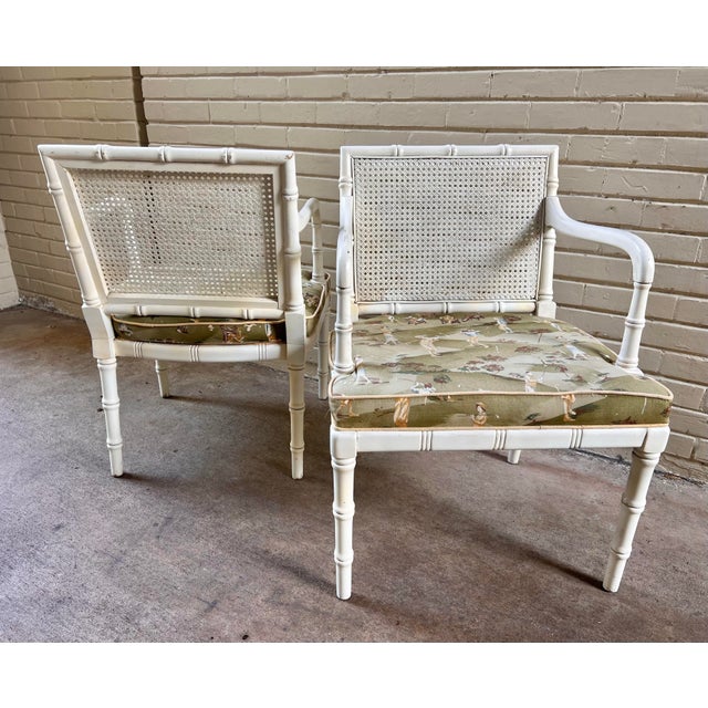 Introducing this exquisite pair of Vintage Faux Bamboo and Cane Backed Armed Side Chairs in Off White with Upholstered...