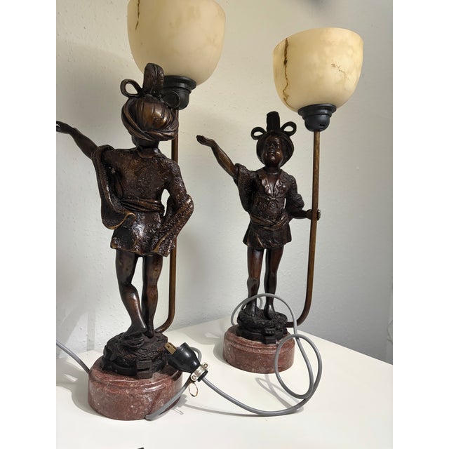Elegant pair of mid-20th-century Italian Venetian style figural table lamps, heavily drawing inspiration from classical...