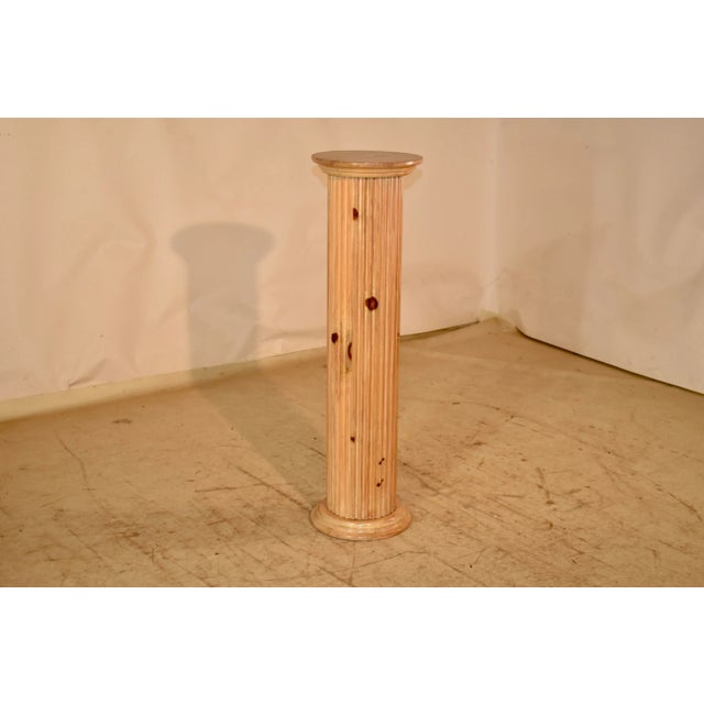 19th century pine pedestal from England. The pedestal has hand turnings on the top and base for added depth and dimension...