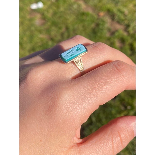 The Lynnfield: Antique Floral Carved Cameo Ring in Yellow Gold. This striking ring showcases an elongated tablet of...