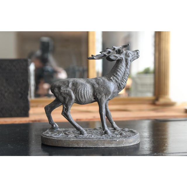 This is a vintage cast-iron or bronze figurine of a stag in mid-call, standing on an oval base, possibly dating to the...