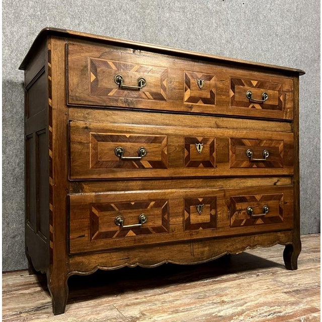 A Grenoble chest of drawers from the Louis XV / Louis XVI transition period in marquetry of noble woods. front opening...