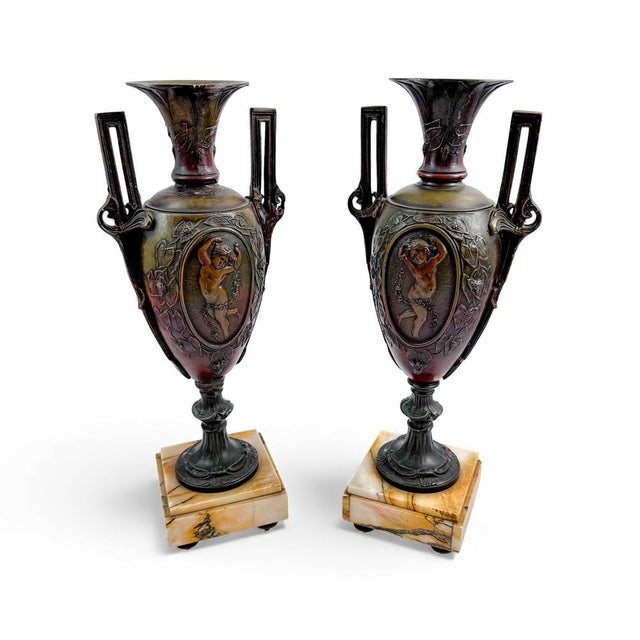 A pair of antique French Amphora-form vases in heavy spelter with dark patina and marble bases. Each vase features a...