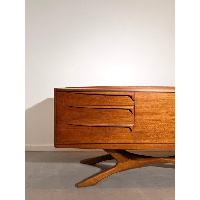 Exceptional vintage sideboard by beithcraft, crafted in beautifully grained teak wood and featuring an elegant sculptural...