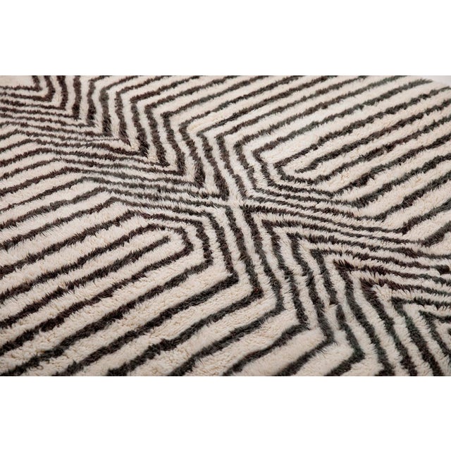 Striking hand-knotted wool rug in Midnight Black, Java and Ivory, featuring a unique abstract pattern. This standout piece...