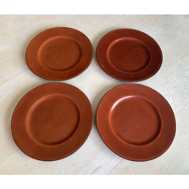 Ralph Lauren leather "Rollins" 13 1/2” plate chargers. They have a beautiful patina, with a rich and smooth surface and...