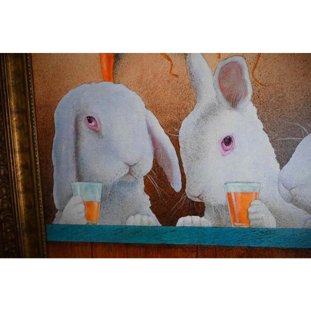 An original painting by Will Bullas: three white rabbits lined up at a bar, each with a glass of carrot juice, while a row...