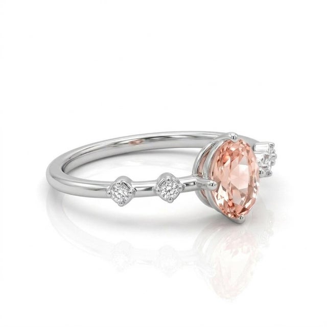 This stunning ring features a soft, blush-toned morganite gemstone, celebrated for its delicate peach-pink hue and...