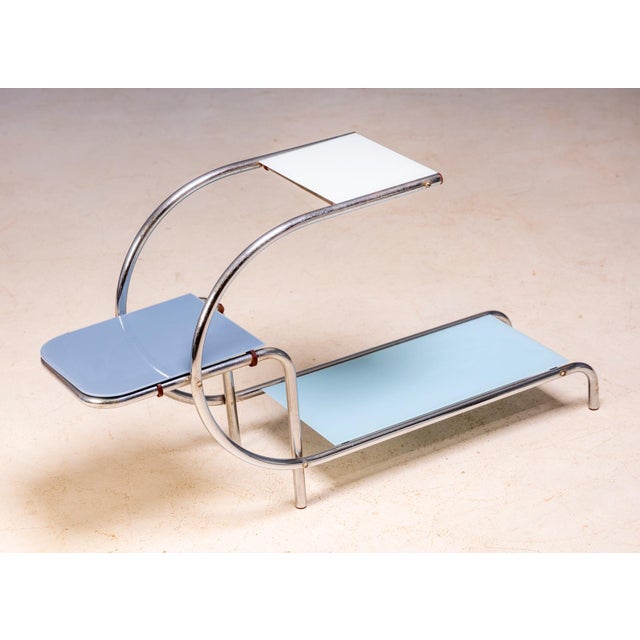 An elegant Bauhaus flower stand featuring a chrome-plated tubular steel frame fitted with new light blue and white glass...