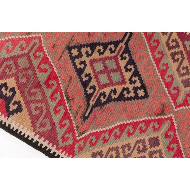 This is a vintage Turkish Oushak rug from the Mid 20th Century. The piece was hand-knotted.